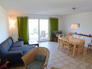 a living room with a blue couch and a table at At the Dune Comfortable holiday residence in Juliusruh