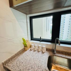 a kitchen counter with a sink and a window at Cozy 2B1R condo Forest City in Gelang Patah