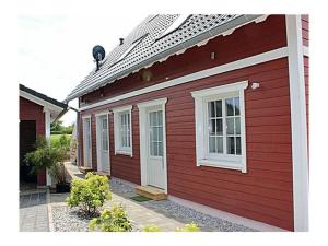 una casa rossa con finestre bianche sul lato di Pameebo 1 Comfortable holiday residence a Drewoldke