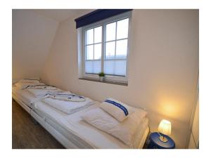 un letto in una stanza con una finestra di Pameebo 1 Comfortable holiday residence a Drewoldke