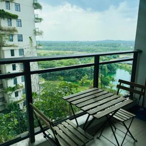 a balcony with a wooden table and chairs and a view at Cozy 2B1R condo Forest City in Gelang Patah