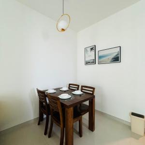 a dining room with a wooden table and chairs at Cozy 2B1R condo Forest City in Gelang Patah