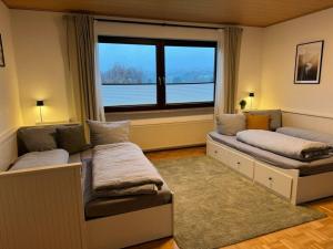 two beds in a room with a large window at Lovely apartment near the water in Weilburg