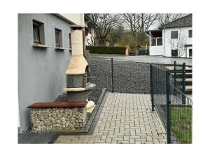 a building with a stone pillar next to a fence at Lovely apartment near the water in Weilburg