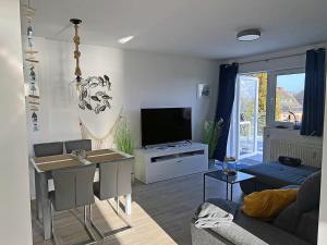 a living room with a table and a television at Lütt Matten Comfortable holiday residence in Dranske
