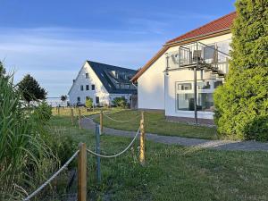 a house with a rope fence in front of it at Lütt Matten Comfortable holiday residence in Dranske