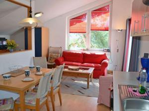 a living room with a red couch and a table at Arkonablick No 66 Comfortable holiday residence in Juliusruh