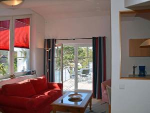 a living room with a red couch and a table at Arkonablick No 66 Comfortable holiday residence in Juliusruh