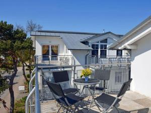 a patio with chairs and a table in front of a house at Arkonablick No 66 Comfortable holiday residence in Juliusruh