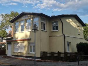 ツィノヴィッツにあるNachtstern Comfortable holiday residenceの前に柵がある黄色い家