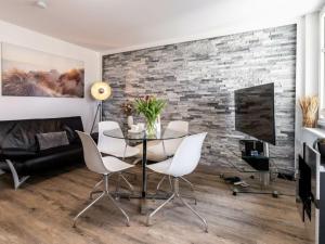 ツィノヴィッツにあるNachtstern Comfortable holiday residenceのガラスのテーブルと白い椅子のあるダイニングルーム