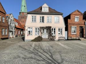 a large white house with a bench in a street at On the Trave Comfortable holiday residence in Travemünde