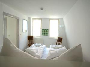 two beds in a room with two chairs at On the Trave Comfortable holiday residence in Travemünde