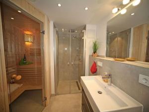a bathroom with a shower and a white sink at Villa Düne "Penthouse Apartment" in Baabe +16 photos