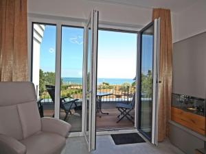 a living room with sliding glass doors leading to a balcony at Villa Düne "Penthouse Apartment" in Baabe