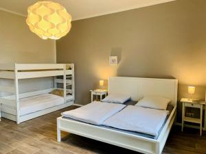 a bedroom with two bunk beds and a chandelier at Roßplatz in the center in Leipzig