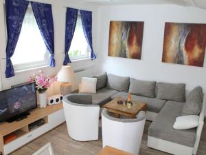 a living room with a couch and a tv at Vulkaneifel Comfortable holiday residence in Daun