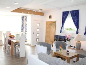 uma sala de estar com cortinas azuis e uma mesa e cadeiras em Vulkaneifel Comfortable holiday residence em Daun