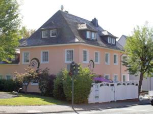 a large pink house with a white fence at Vulkaneifel Comfortable holiday residence in Daun
