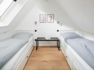 two beds in a room with a table at Mooi 2 Comfortable holiday residence in Norderney