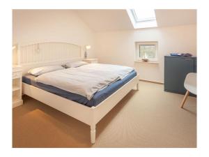 a bedroom with a bed and a desk and a window at Three-master house no 5 in Breege