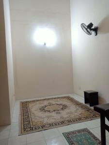 Habitación blanca con alfombra en una pared blanca en Salak Indah Homestay KLIA/KLIA2 en Sepang