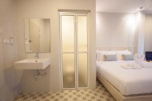 a bathroom with a bed with a sink and a mirror at Nature Pine Residence in Rawai Beach