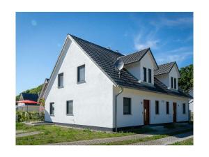 a white house with a black roof at Meerzeit Comfortable holiday residence in Juliusruh