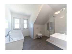 a white bathroom with a sink and a toilet at Meerzeit Comfortable holiday residence in Juliusruh