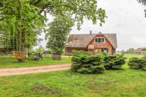 a house in the middle of a field at Lauku viesu māja Bajāri in Rucava