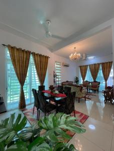 a large living room with a table and chairs at Idaman Maya in Kluang