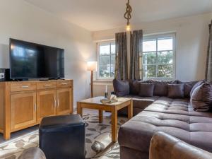 a living room with a couch and a flat screen tv at Luxury house R1 Comfortable holiday residence in Sankt Peter-Ording
