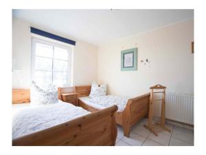 a bedroom with two beds and a window at Luxury house R1 Comfortable holiday residence in Sankt Peter-Ording