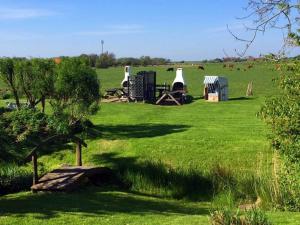 a field with tents and cows in the background at Luxury house R1 Comfortable holiday residence in Sankt Peter-Ording