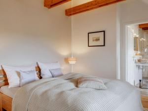 una camera da letto con un grande letto bianco con cuscini bianchi di House Uelvesbüll - West a Uelvesbüll