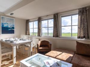 a living room with a table and a couch and windows at Luxury house R2 with view in Sankt Peter-Ording +18 photos