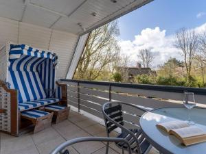 a patio with a table and chairs on a balcony at Luxury house R2 with view in Sankt Peter-Ording