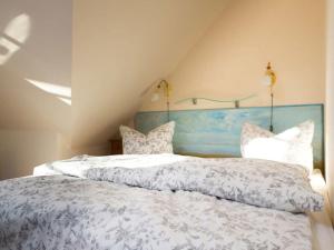 a bedroom with two beds with white blankets and pillows at Luxury house R2 with view in Sankt Peter-Ording