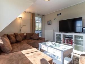 a living room with a couch and a flat screen tv at Luxury house R2 with view in Sankt Peter-Ording