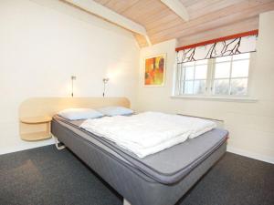 Schlafzimmer mit einem Bett, einem Schreibtisch und einem Fenster in der Unterkunft Lynglihus Ly92 in Hvide Sande