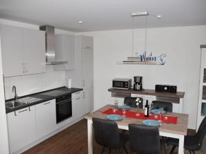 a kitchen with a table and chairs in it at Anchorage Comfortable holiday residence in Fedderwardersiel +24 photos