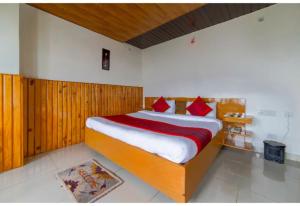 ein Schlafzimmer mit einem großen Bett mit roten Kissen in der Unterkunft Goroomgo Bala Paradise Munsyari in Munsyari
