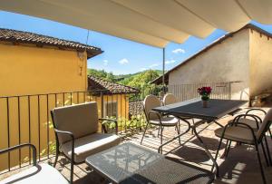 een patio met een tafel en stoelen en een hek bij La Giolitta Rooms & Apartment in Barolo