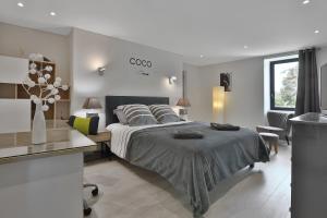 1 dormitorio con 1 cama grande, mesa y sillas en Ferme des Petites Oreilles 4 étoiles en Montignac