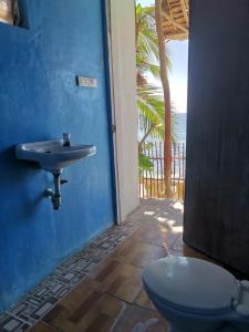 a blue bathroom with a sink and a toilet at Sea Esta Beach House in Boljoon