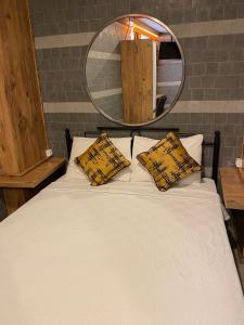 1 cama blanca con 2 almohadas y espejo en M-ODA OTEL, en Antalya