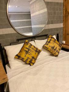安塔利亞的住宿－M-ODA OTEL，一张带两个黄色枕头和镜子的床