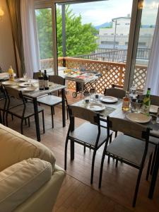 uma sala de jantar com mesas e cadeiras e uma varanda em Bigstone Terrace suite　堤町 em Aomori
