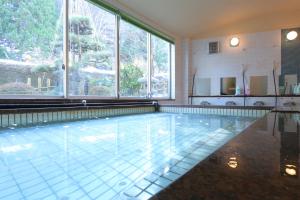 Muraoka的住宿－Ryokan Nakaya，大型游泳池设有大窗户