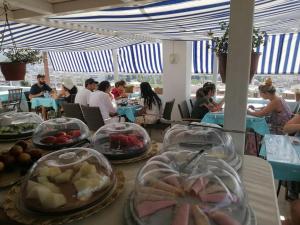 庫薩達斯的住宿－Ephesian Hotel & Guesthouse，一群坐在餐厅餐桌旁吃饭的人